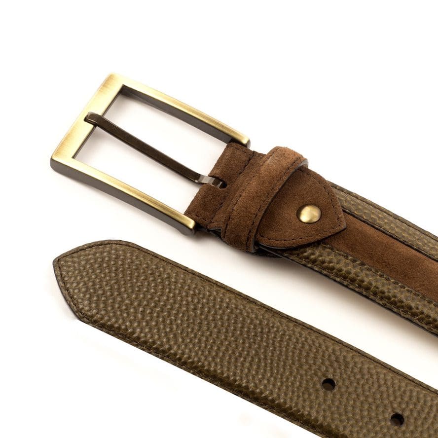 Detail van een pebble met suède riem met koperkleurige gesp.