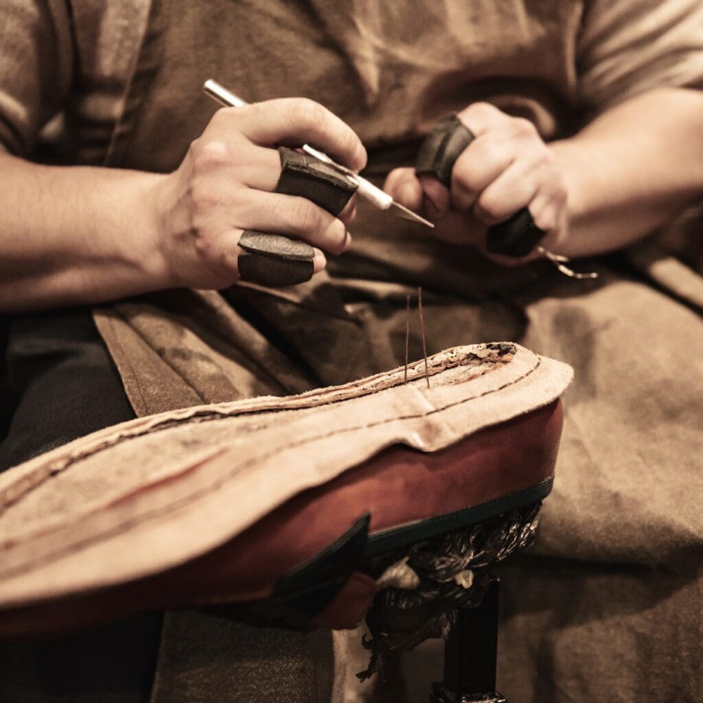 Schoenmaker naait handmatig een Goodyear welt zool.