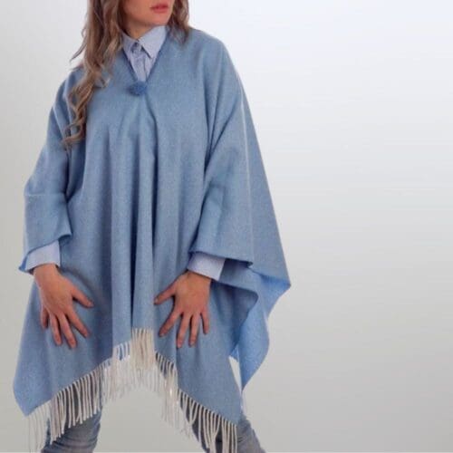 Model met een lichtblauwe lamswollen poncho van Grazalema