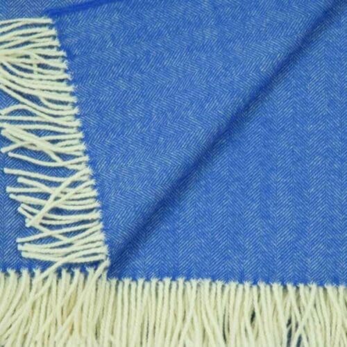 Detail van een lamswollen omslagdoek met franjes