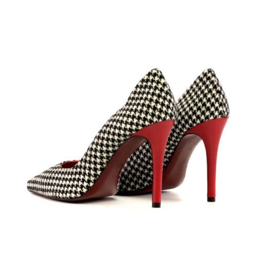 Houndstooth pumps met rode naaldhakken van 10 cm hoog.