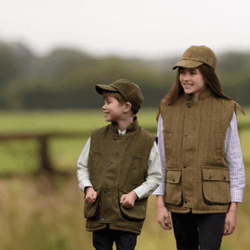 jongen en meisje gekleed in tweed shooting gilet